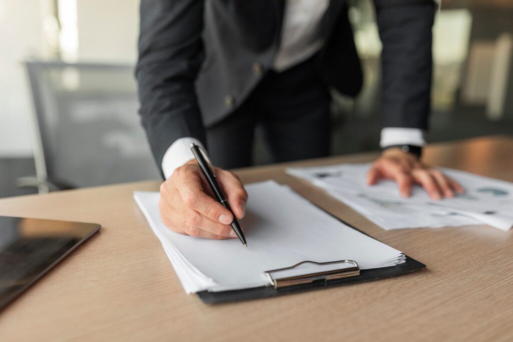 Male entrepreneur signing contract, putting signature on official documents, selective focus on